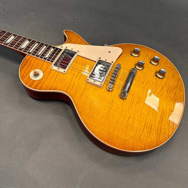 Electric guitar with sunburst finish, dual humbucker pickups, four control knobs, and a toggle switch on a gray background