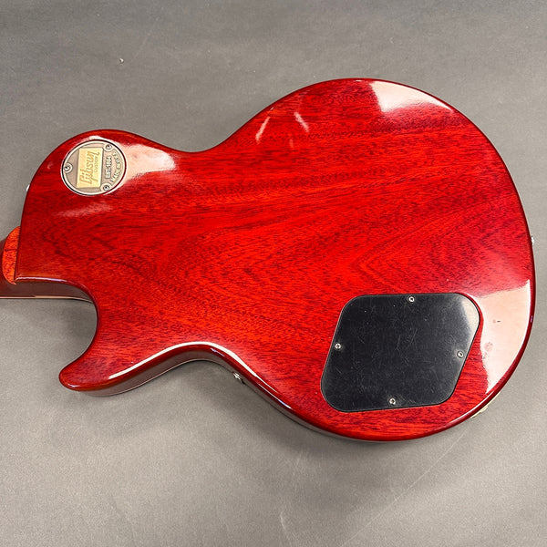 Back view of red Gibson Les Paul electric guitar showing wood grain and control cavity cover