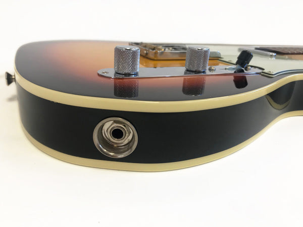 Close-up of electric guitar sunburst finish body with chrome control knobs and input jack, cream binding, and black side panel, isolated on white background