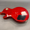 Back side view of cherry red electric guitar body with black control cover plate and vintage Gibson Custom Shop metal badge