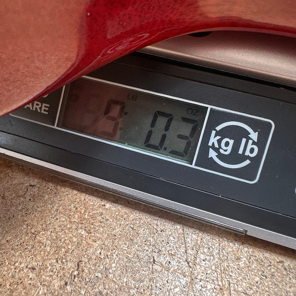Close-up of digital scale displaying weight 9 pounds 0.3 ounces for guitar measurement at Coffee House Guitars
