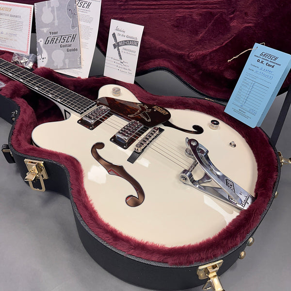 Gretsch white hollow body electric guitar with Bigsby tremolo in open black hard case with burgundy plush lining and included Gretsch manuals and warranty cards.