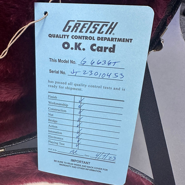 Gretsch Quality Control Department O.K. Card for guitar model G4636T with serial number JT23010453 showing quality checks for finish, workmanship, construction, nut, bridge, action, intonation, electronics, and playing test, dated 4/7/23 inside a guitar case with red velvet lining.