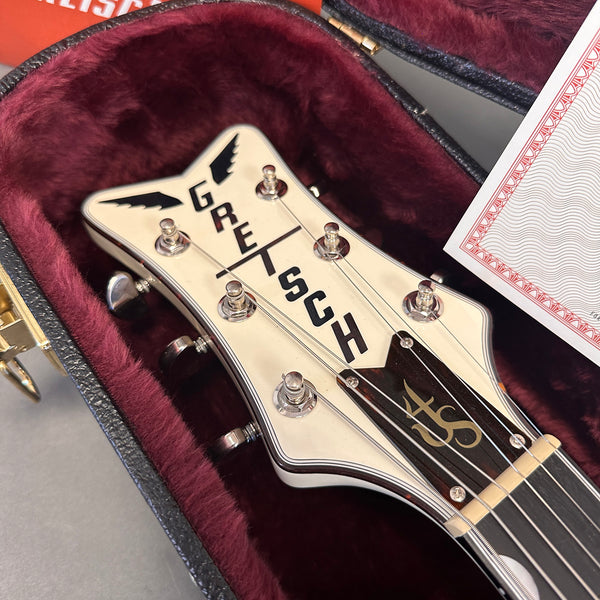 Close-up of Gretsch guitar headstock with tuning pegs inside plush red velvet guitar case at Coffee House Guitars