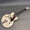 Gretsch vintage-style hollow body electric guitar in white with Bigsby tremolo, dual humbucker pickups, tortoiseshell pickguard featuring eagle design, and black bound neck with intricate inlays.