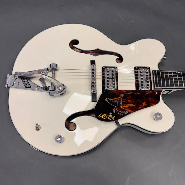 White Gretsch hollow body electric guitar with Bigsby vibrato tailpiece and double humbucker pickups on gray background