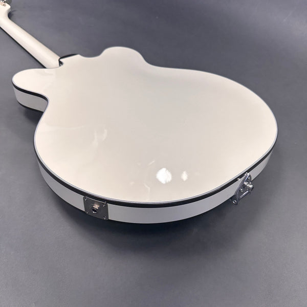 Glossy white semi-hollow electric guitar back with chrome hardware and black binding on dark gray background