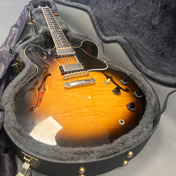 Semi-hollow body electric guitar with sunburst finish inside a plush lined hard case, featuring dual humbucker pickups and four control knobs