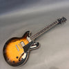 Gibson semi-hollow body electric guitar with sunburst finish, dual humbucker pickups, black pickguard, and rosewood fretboard on gray background