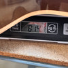 Close-up of a digital scale displaying the weight 8.14 pounds with the edge of a guitar body resting on it, showing the weight measurement of the guitar for Coffee House Guitars product listing.