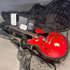Red semi-hollow Gibson electric guitar with black pickguard and chrome hardware inside black plush-lined hardshell case with certificate of authenticity and final pack checklist papers
