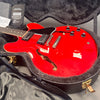 Red Gibson semi-hollow electric guitar with black pickguard and dual humbucker pickups in open black hard case with certificate of authenticity