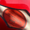 Close-up of Gibson guitar label inside red guitar showing model and serial number, guaranteed against faulty workmanship and materials.