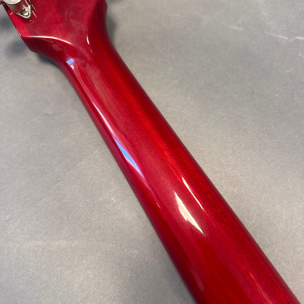 Glossy red guitar neck with smooth finish on gray background