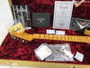 Fender guitar case interior with 1951 Nocaster Relic neck, Fender Certificate of Authenticity, Fender Custom Shop manual, cleaning cloth, silica gel packets, truss rod adjustment tool, and Fender Custom Shop promotional materials on red plush lining.