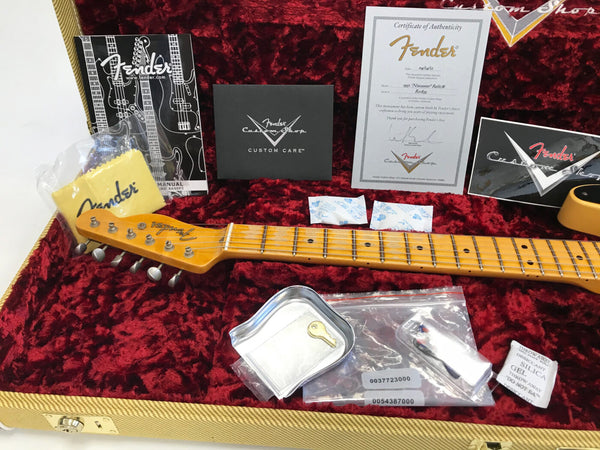 Fender guitar case interior with 1951 Nocaster Relic neck, Fender Certificate of Authenticity, Fender Custom Shop manual, cleaning cloth, silica gel packets, truss rod adjustment tool, and Fender Custom Shop promotional materials on red plush lining.