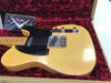 Vintage Fender Telecaster electric guitar in butterscotch blonde finish with black pickguard, displayed in a red velvet-lined tweed hard case, showing signs of wear and relic finish.