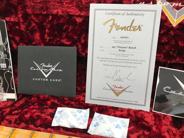Fender Custom Shop Certificate of Authenticity for 1951 Nocaster Relic guitar with serial number R11839 displayed on red plush guitar case lining alongside Fender Custom Shop Custom Care booklet and silica gel packets.