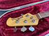 Fender MusicMan StingRay bass guitar headstock with tuning pegs in red velvet guitar case