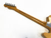 Vintage electric guitar maple neck with six tuning pegs and a visible skunk stripe on a light yellow guitar body against a white background