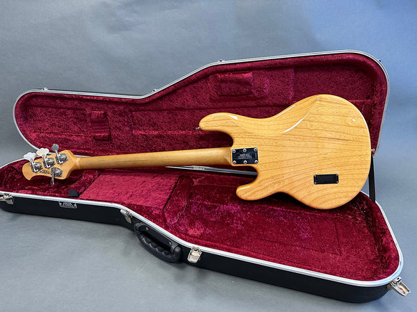 Natural wood finish electric bass guitar back view in open hard case with red velvet lining