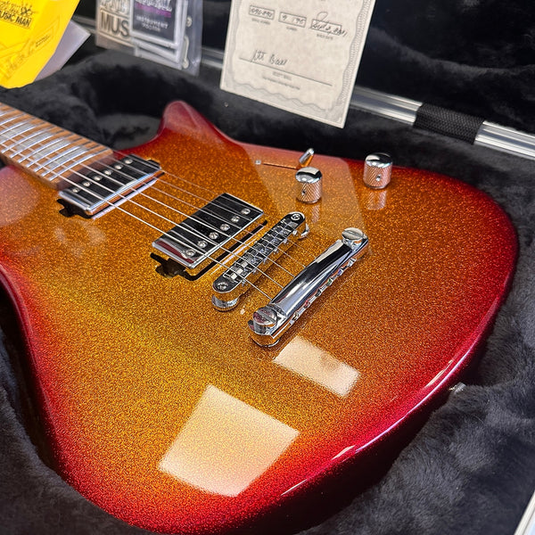 Electric guitar with glittery gold and red finish, chrome bridge, and dual humbucker pickups in plush black case