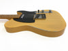 Vintage yellow electric guitar with black pickguard and maple neck showing wear and chipped paint on body