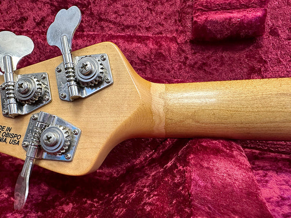 Close-up of maple guitar neck and tuning pegs on red velvet background, showing craftsmanship and "Made in San Obispo, California, USA" marking.
