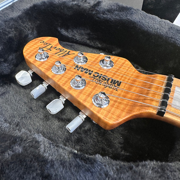 Ed Roman Musicman Silhouette guitar headstock with tuning pegs and strings in a black plush case
