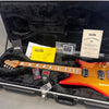 Ernie Ball Music Man signature electric guitar with flamed maple neck and sunburst orange sparkle finish in black plush-lined hard case with certificate of authenticity and accessory documentation.