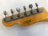 Vintage Fender Custom Shop guitar headstock with six aged metal tuning pegs on natural wood finish showing wear and Fender Custom Shop logo.