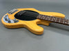 Natural wood finish electric bass guitar with black pickguard and chrome control knobs on gray background