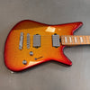 Electric guitar with metallic orange and red finish, dual humbucker pickups, chrome bridge, volume and tone knobs, and maple fretboard with block inlays on gray background
