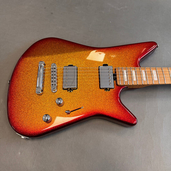Electric guitar with metallic orange and red finish, dual humbucker pickups, chrome bridge, volume and tone knobs, and maple fretboard with block inlays on gray background