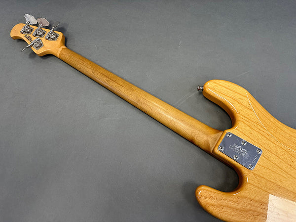 Back view of vintage Tene Bell electric bass guitar with natural wood finish and chrome tuning pegs on gray background