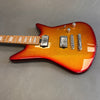 Electric guitar with sparkling red to orange sunburst finish, dual humbucker pickups, chrome bridge, and maple neck with rectangular inlays on gray background