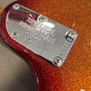 Close-up of Ernie Ball Music Man guitar neck plate on red and orange sparkle finish electric guitar body with serial number code 96292