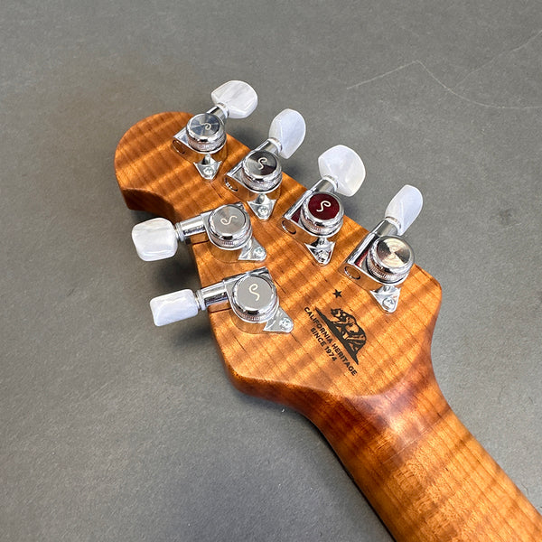 Close-up of guitar headstock with chrome tuning pegs and California Heritage "Since 1971" logo on figured wood neck