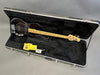 Black electric bass guitar with maple neck in open hard case with polishing cloth, strap, and key inside, Coffee House Guitars product listing image