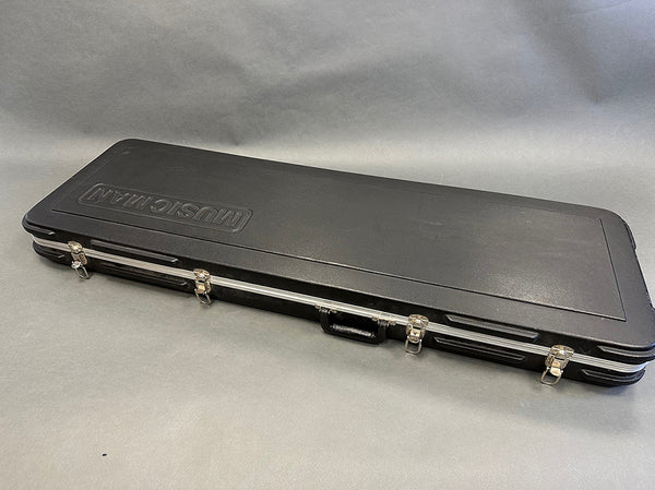 Black MusiCman hard guitar case with metal latches and handle on gray background for electric guitar storage and protection