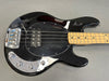 Black electric bass guitar with maple fretboard, chrome bridge, and control knobs on grey background