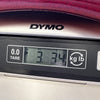 Close-up of DYMO digital scale showing 3.34 kilograms weight measurement for guitar product listing at Coffee House Guitars