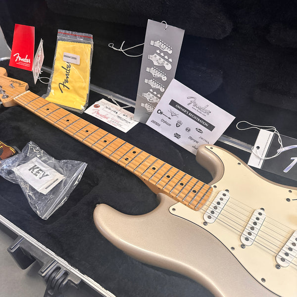 Fender electric guitar with maple neck and pearl finish in black hardshell case including Fender owner's registration, tags, polishing cloth, and plastic packaging with key accessory from Coffee House Guitars.