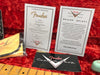 Fender Custom Shop certificate of authenticity and dealer select documents on red velvet background with guitar neck and Fender cleaning cloth.