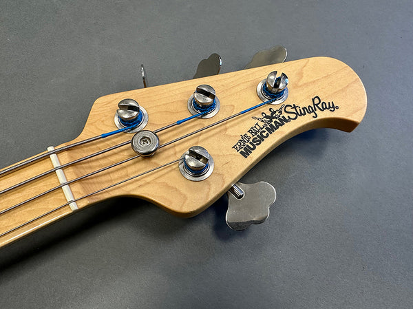Ernie Ball Music Man StingRay bass guitar headstock with tuning pegs and strings on gray background