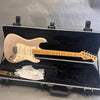 Fender Stratocaster electric guitar in metallic champagne finish with maple neck and fretboard, in black plush-lined hard case with Fender strap and plastic packaging.