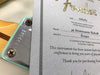 Fender 59 Stratocaster Relic certificate with serial number R72922 next to matching guitar neck plate close-up
