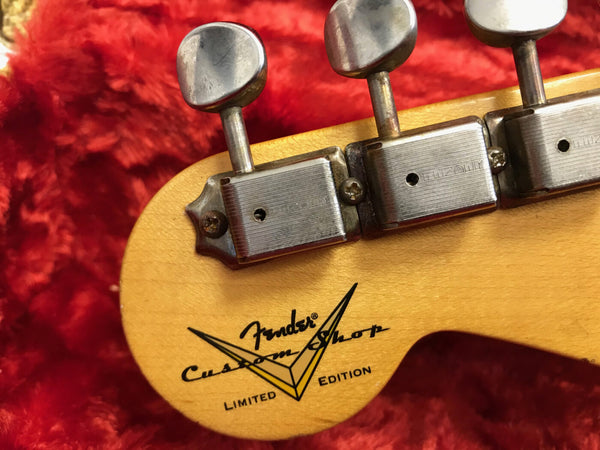 Close-up of Fender Custom Shop Limited Edition guitar headstock with vintage tuners on red plush background
