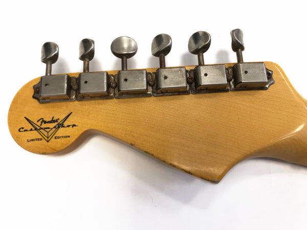 Close-up of vintage Fender Custom Shop Limited Edition guitar headstock with six tuning pegs on natural wood finish background