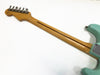 Back view of maple neck and vintage tuners on a light blue Fender Stratocaster electric guitar against a white background